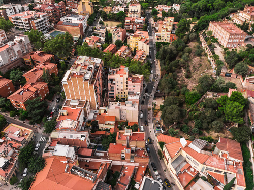 Drone shot Park Guell in Barcelona. Panoramic view of the city of Barcelona. Spain from drone. Park at the top of Barcelona. Drone view of gardens and residential areas in Spain.
