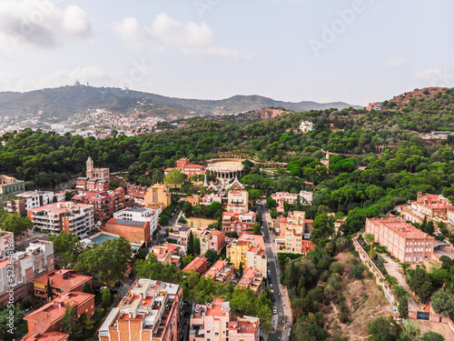 Drone shot Park Guell in Barcelona. Panoramic view of the city of Barcelona. Spain from drone. Park at the top of Barcelona. Drone view of gardens and residential areas in Spain.