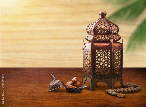 Ramadan Kareem still life. Ornamental lantern on old wooden table background. Muslim Iftar dinner.