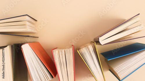 Pastel beige background with vintage colorful books. Flat lay copy space