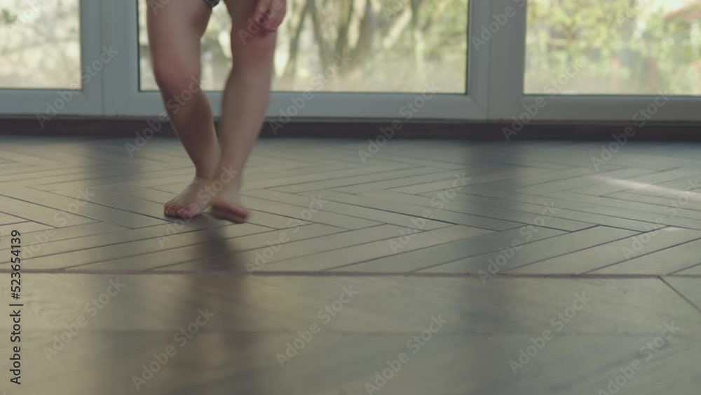 child kid barefoot legs playing with ball at home, little baby boy plays soccer in living room on floor. toddler jumps, runs, catches ball. active games indoors, happy childhood concept child kid barefoot legs playing with ball at home, little baby boy plays soccer in living room on floor. toddler jumps, runs, catches ball. active games indoors, happy childhood concept