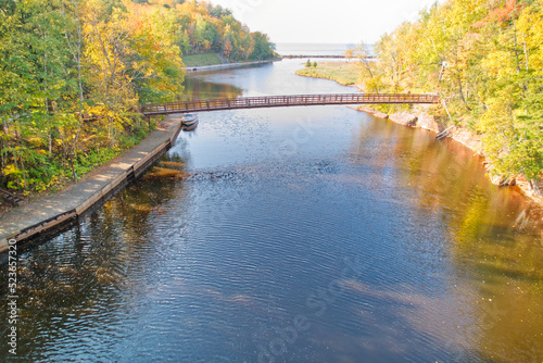 Aerial perspective of a wood bridge over a river leading into Lake Michigan in Upper Michigan