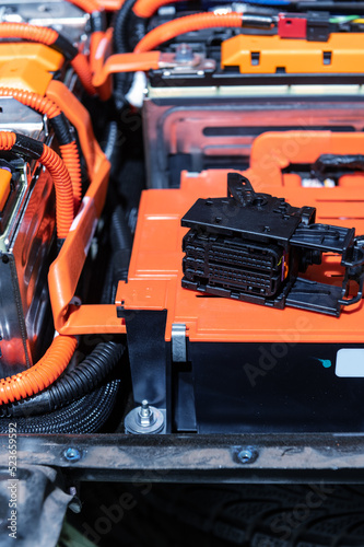 Electric car battery with power connections closeup. Blue toned. EV car battery at maintenance. High voltage power connector closeup.