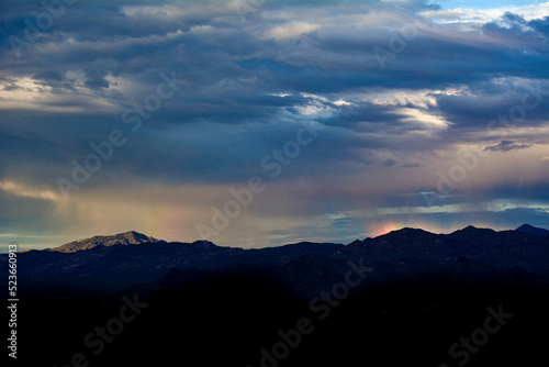 Rain falling on the Arizona Mountain Range with Sun Dog Rainbow Reflection in Clouds