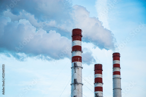 Air pollution. Smoking chimneys against blue sky.