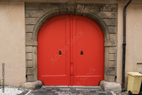Bright vintage orange colored wooden door entrance of building garage front view outdoor © Bonsales