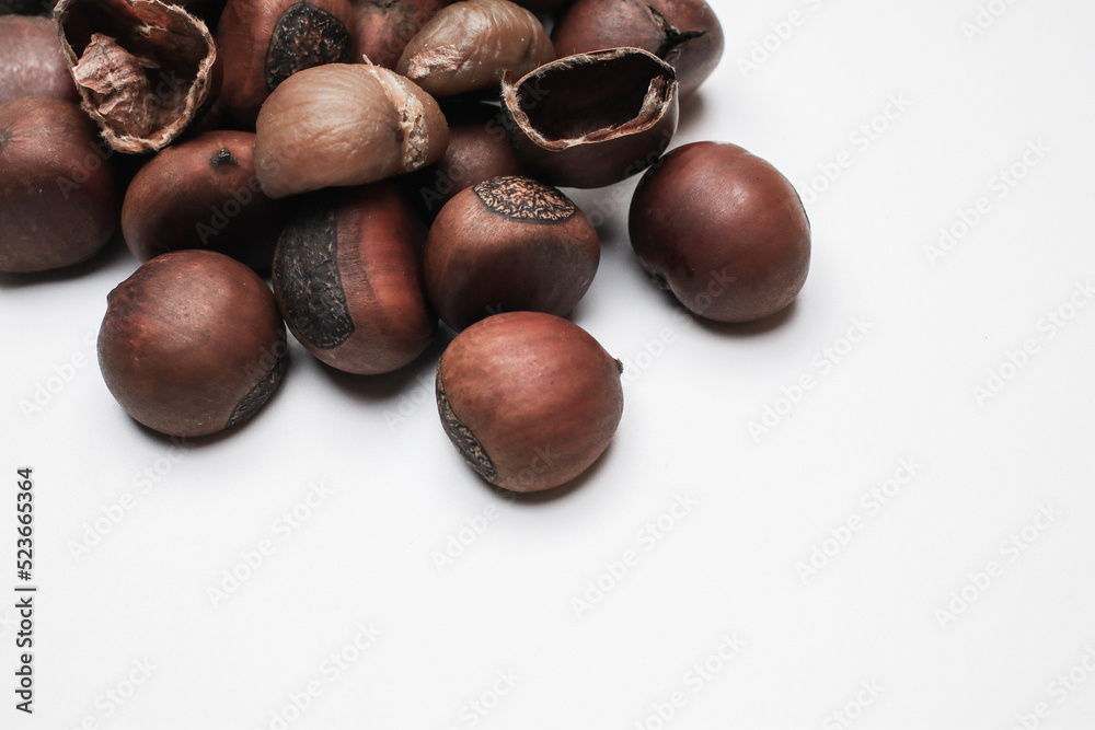 Chestnuts on white background. Pile of fresh chestnuts ready to roast. Top view, copy space. Flat lay. Space for text Chestnuts on white background. Pile of fresh chestnuts ready to roast. Top view, copy space. Flat lay. Space for text