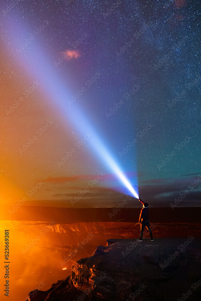 Night sky with stars and volcano light and silhouette of a standing ...