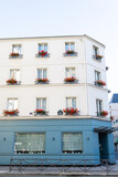 White and blue building with red flowers in Paris