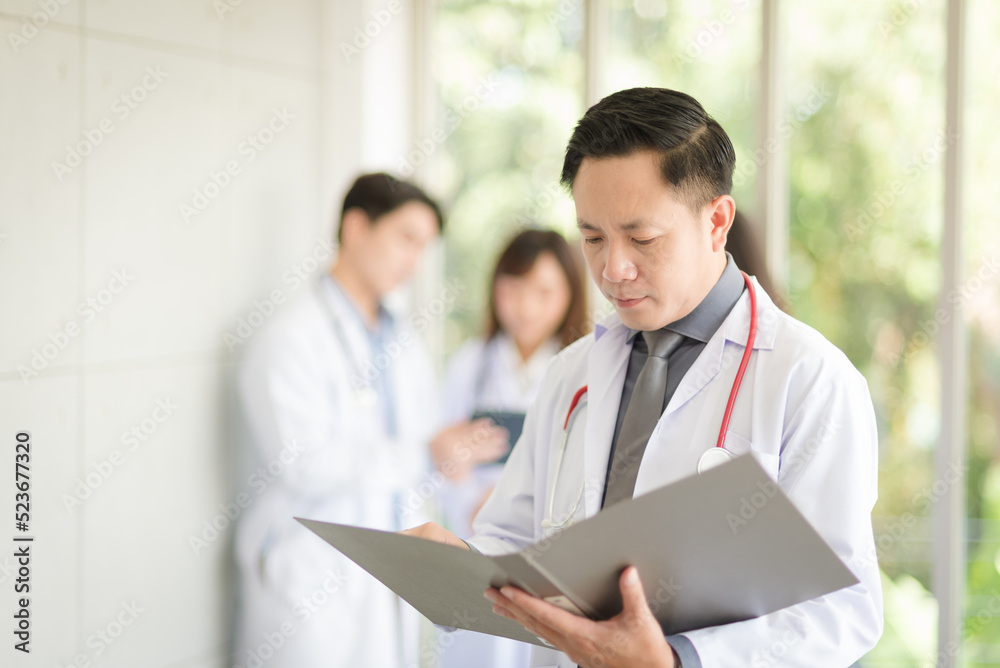 Asian doctor man portrait standing and holding folder to review data with smile and confidence. Asian doctor man portrait standing and holding folder to review data with smile and confidence.