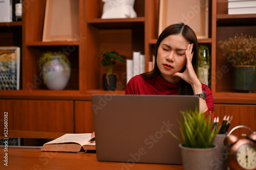 Stressed and frustrated Asian businesswoman suffering from headache © bongkarn