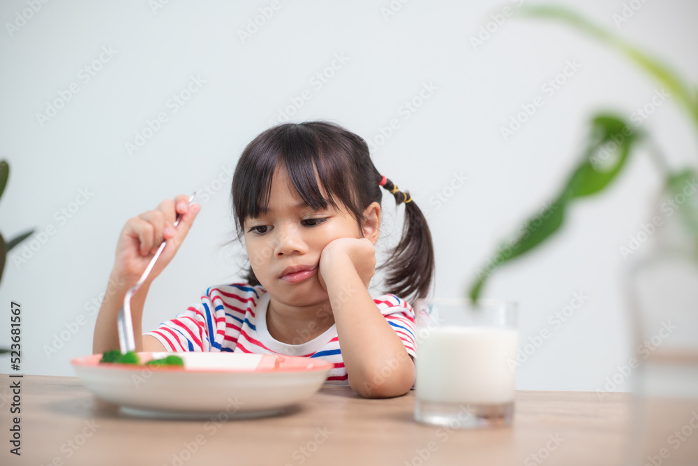 Nutrition & healthy eating habits for kids concept. Children do not like to eat vegetables. Little cute girl refuses to eat healthy vegetables. Nutrition & healthy eating habits for kids concept. Children do not like to eat vegetables. Little cute girl refuses to eat healthy vegetables.