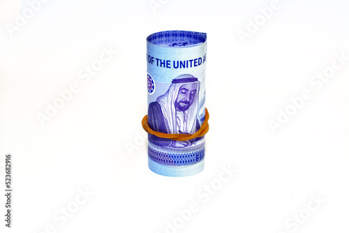 Emirates money roll with Sheikh Zayed bin Sultan Al Nahyan signing the union document from the reverse side of the new polymer commemorative 50 fifty Dirhams of Emirates UAE isolated on white
