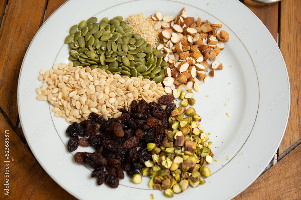 Close up shot a dish full of different seeds and nuts, chestnut,almond, raisin, pumpkins, seasame. Healthy eating concept Close up shot a dish full of different seeds and nuts, chestnut,almond, raisin, pumpkins, seasame. Healthy eating concept