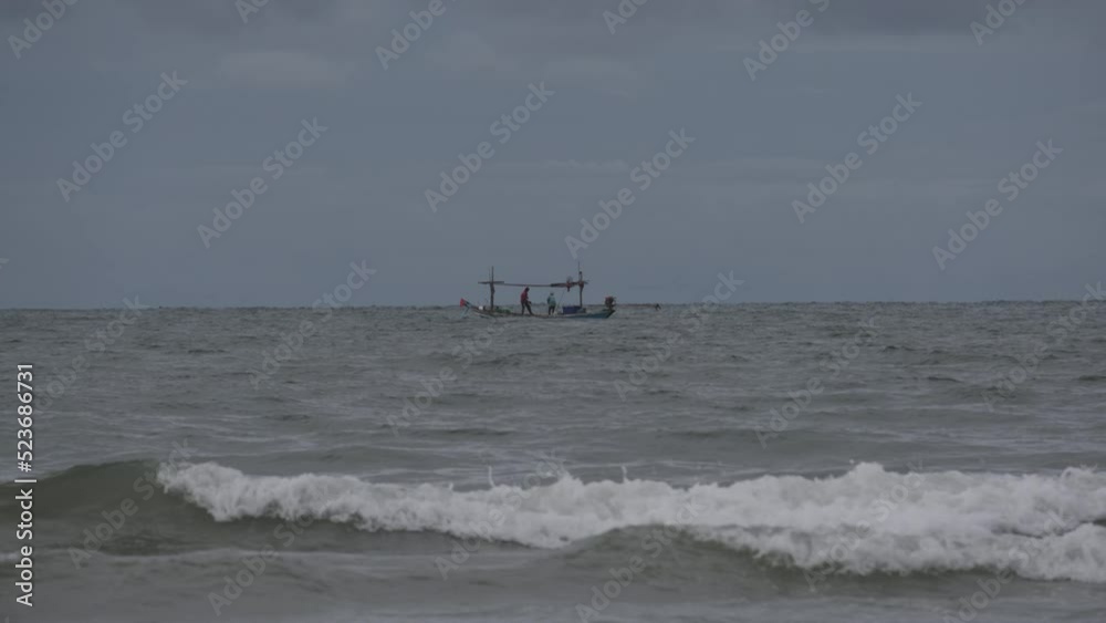 Overcast skies and strong sea waves with fisherman boats floating in the sea. Thailand sea during the rainy season Overcast skies and strong sea waves with fisherman boats floating in the sea. Thailand sea during the rainy season