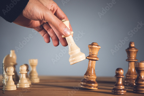 Male businessman plays chess in office