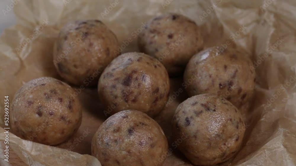 Useful homemade sweets. Coconut flour with dark chocolate. In the form of balls. On pine boards. Slider camera. Useful homemade sweets. Coconut flour with dark chocolate. In the form of balls. On pine boards. Slider camera.