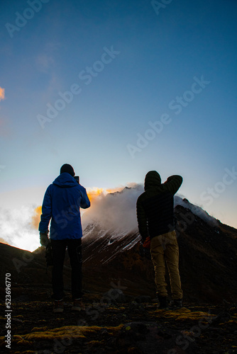 silhouette of a man and a person on a mountain top