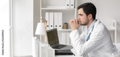 Religious doctor praying in...