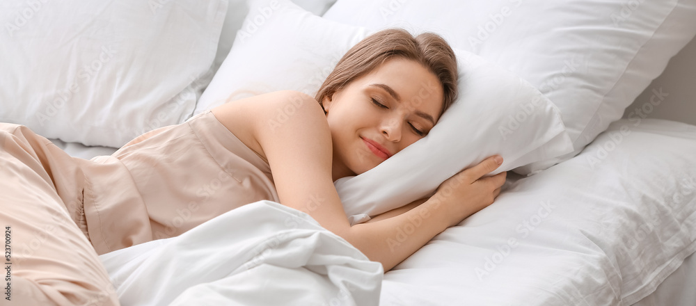 Beautiful young woman sleeping in bed