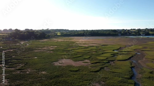 Aerial view panning across Traeth Coch scenic cracked salt marsh moorland countryside at sunset photo