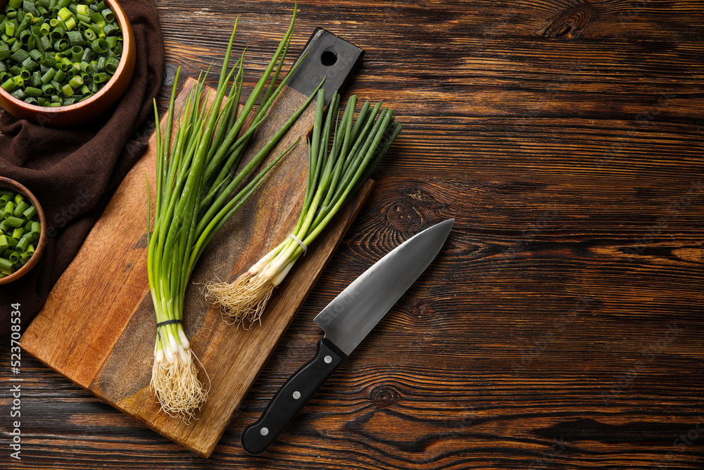 Composition with bunches of fresh green onion on wooden background Composition with bunches of fresh green onion on wooden background