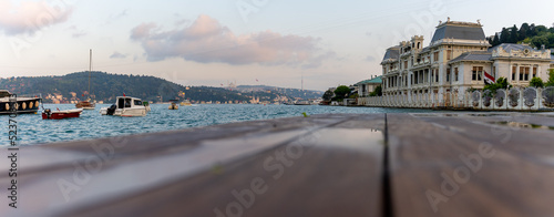 Canvas Print View of the bosphorus, boats, courtyard bench and historical mansions from the beach