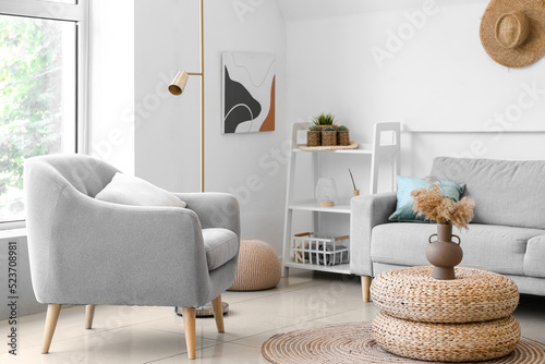 Interior of cozy living room with rattan poufs and armchair