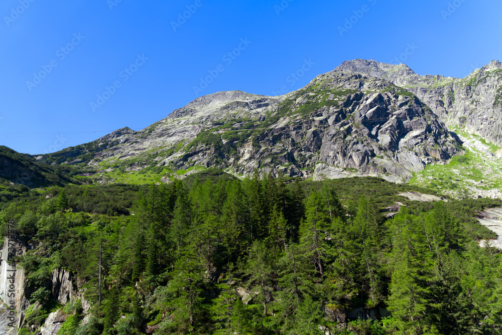 Mountain panorama at Swiss mountain pass Grimsel, Canton Bern, on a sunny summer day. Photo taken July 3rd, 2022, Grimsel Pass, Switzerland.