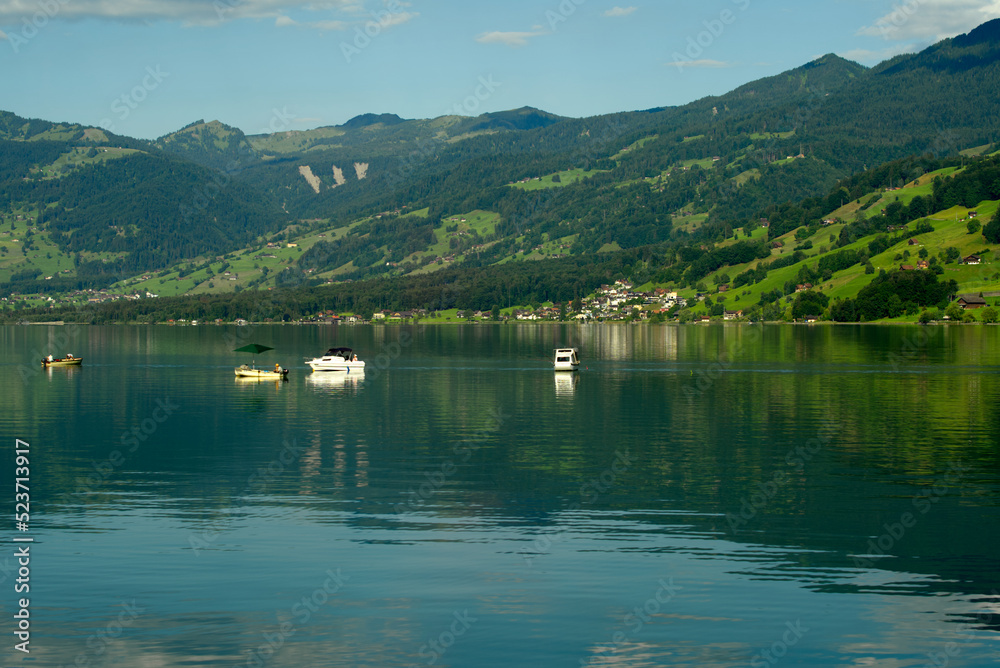 Scenic view of Lake Sarnen, Canton Obwalden, with meadows, houses and fisher boats on a sunny summer day. Photo taken July 3rd, 2022, Lungern, Switzerland.