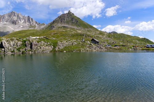 Summit of Nufenen Pass with lake in the Swiss Alps on a sunny summer day. Photo taken July 3rd  2022  Nufenen Pass  Switzerland.