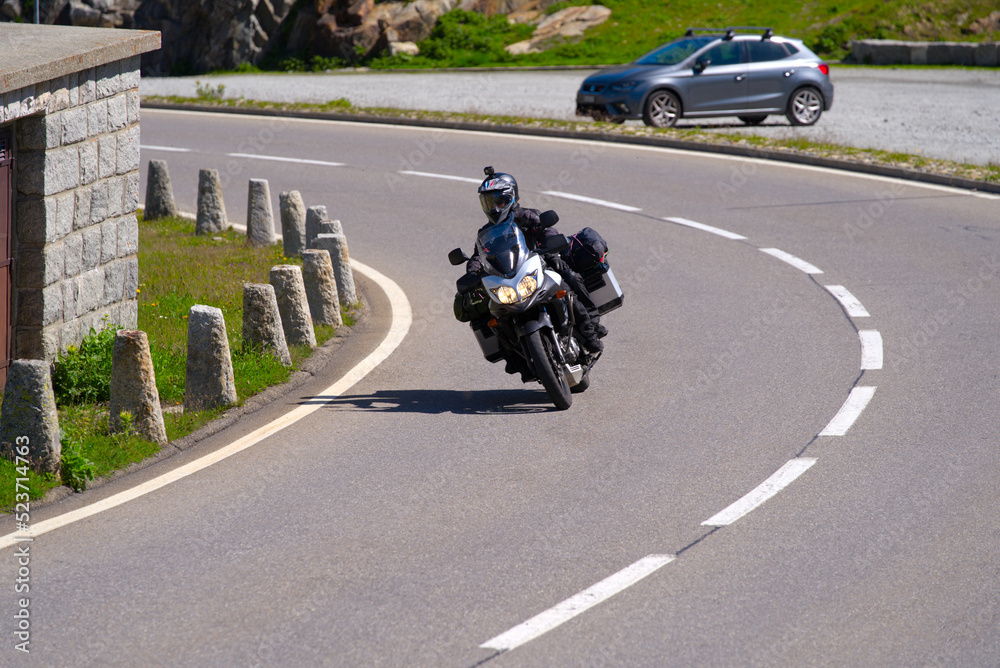Biker with helmet camera at summit of Swiss mountain pass Grimsel on a sunny summer day. Photo taken July 3rd, 2022, Grimsel Pass, Switzerland.