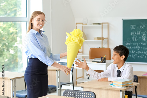Teacher greeting little boy...
