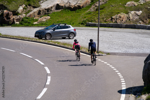 Bicycle couple on the way down form Swiss mountain pass Grimsel on a sunny summer day. Photo taken July 3rd, 2022, Grimsel Pass, Switzerland.