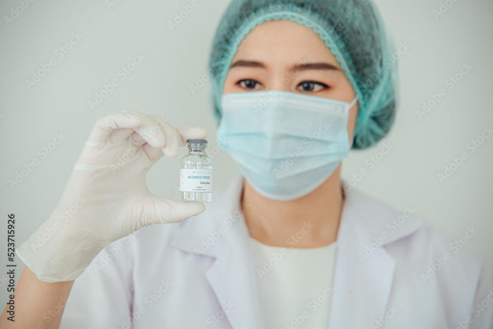 A doctor or scientist is holding a vaccine vial for monkeypox or clade. A doctor or scientist is holding a vaccine vial for monkeypox or clade.