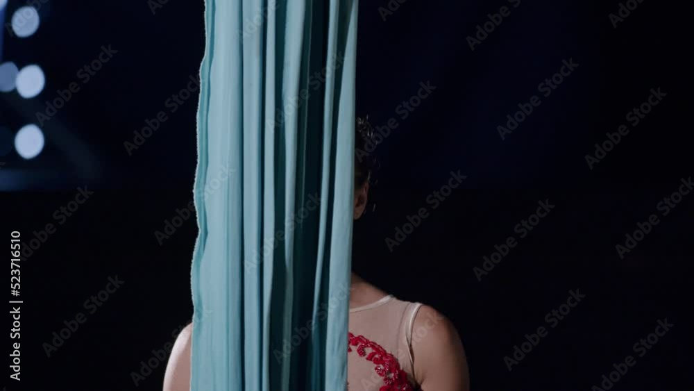 Aerial silk acrobat preparing and standing behind tissue rope Aerial silk acrobat preparing and standing behind tissue rope