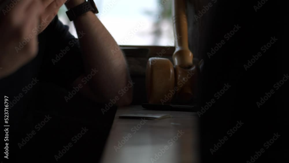 Close shot of friends playing cards and communicate, man taps fingers on table checking or passing Close shot of friends playing cards and communicate, man taps fingers on table checking or passing