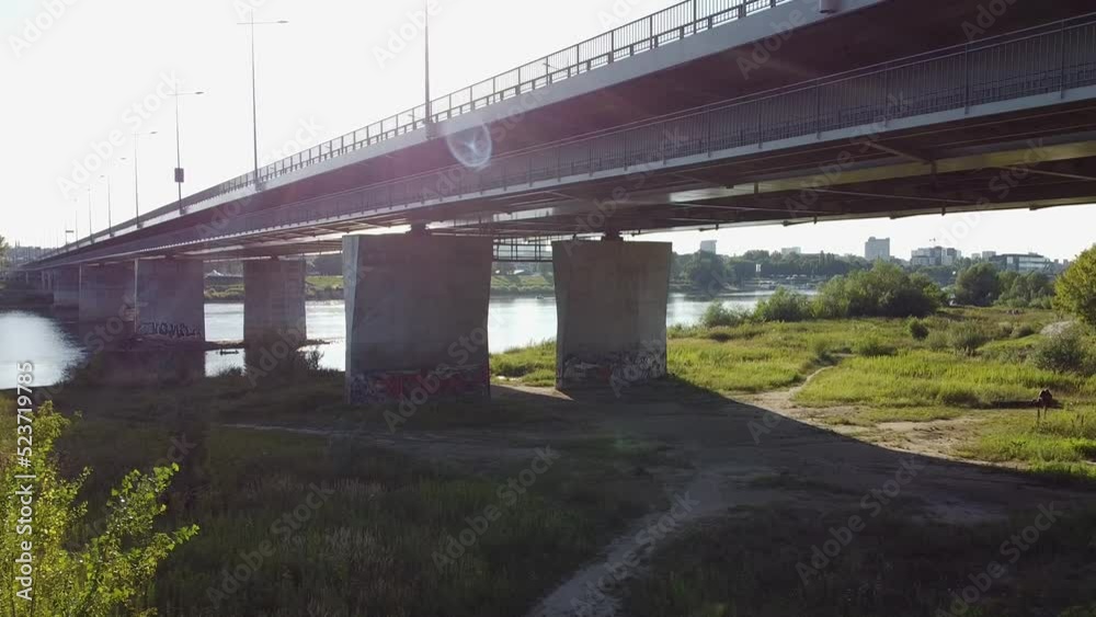 Aerial drone shot of under the bridge while a person carries and walks looking to vista river Warsaw Poland Aerial drone shot of under the bridge while a person carries and walks looking to vista river Warsaw Poland