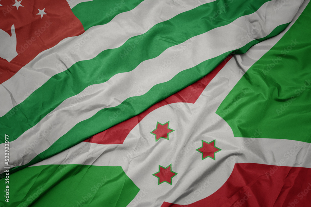 waving colorful flag of burundi and national flag of abkhazia.