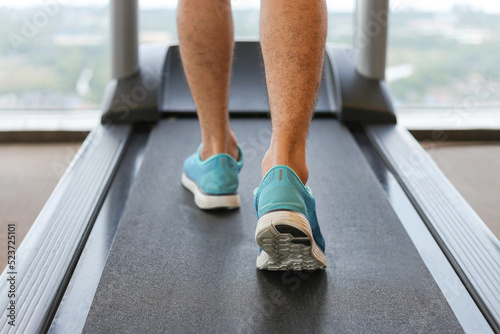 Man running in a gym on a treadmill.