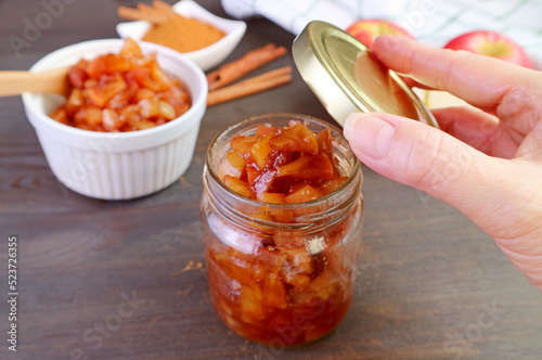 фотографія Delectable homemade caramelized apple cinnamon compote being stored in glass jar