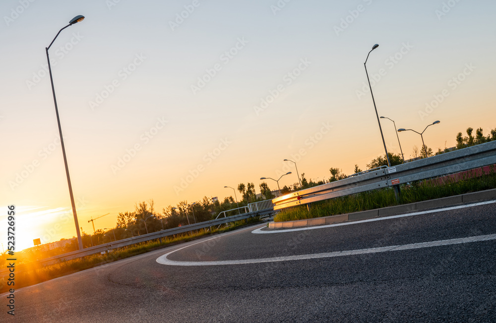Fototapeta premium bend in the asphalt road during sunset