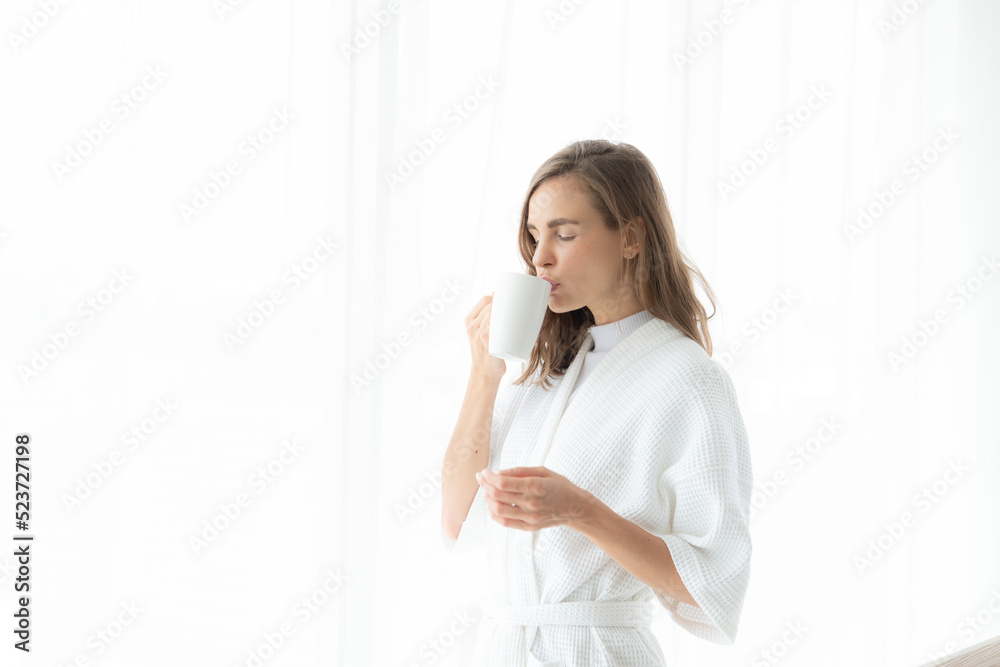 beautiful woman drinking coffee or milk in the morning by the window. view from outside. She drinking milk after wake up in the morning beautiful woman drinking coffee or milk in the morning by the window. view from outside. She drinking milk after wake up in the morning