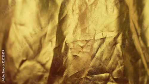 Wrinkled golden color cloth background with changing light photo