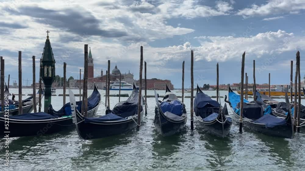 Gondolas in Venice side by side moving on the water Gondolas in Venice side by side moving on the water