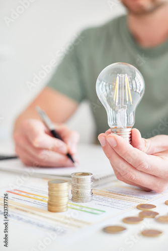 Mann am Schreibtisch macht Berechnungen zum Thema Sparen, Energie, Heizkosten und Umwelt
