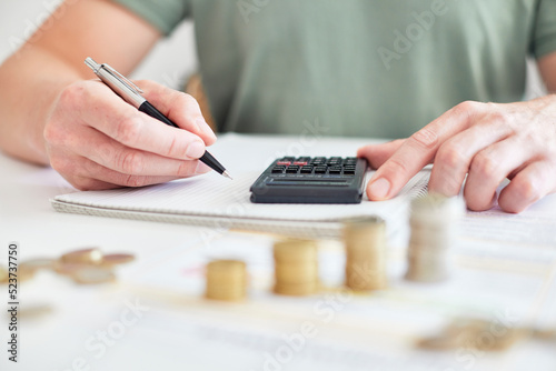 Mann am Schreibtisch macht Berechnungen zum Thema Sparen, Energie, Heizkosten und Umwelt photo