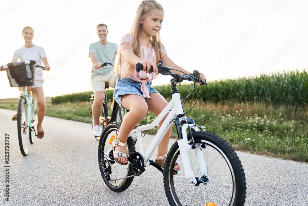 Caucasian family of three while bike ride on village road Caucasian family of three while bike ride on village road