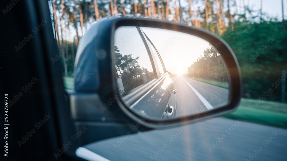 Road sunset car mirror. Summer sun, highway car road reflection in mirror. Vacation trip concept.