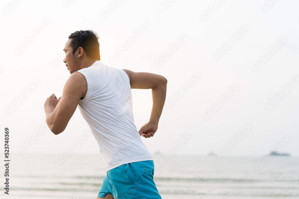 asian sport man running along seaside. running on beach with healthy toned legs body, Hamstring muscles, knee joint health active lifestyle panoramic banner background. the beach runners working out asian sport man running along seaside. running on beach with healthy toned legs body, Hamstring muscles, knee joint health active lifestyle panoramic banner background. the beach runners working out